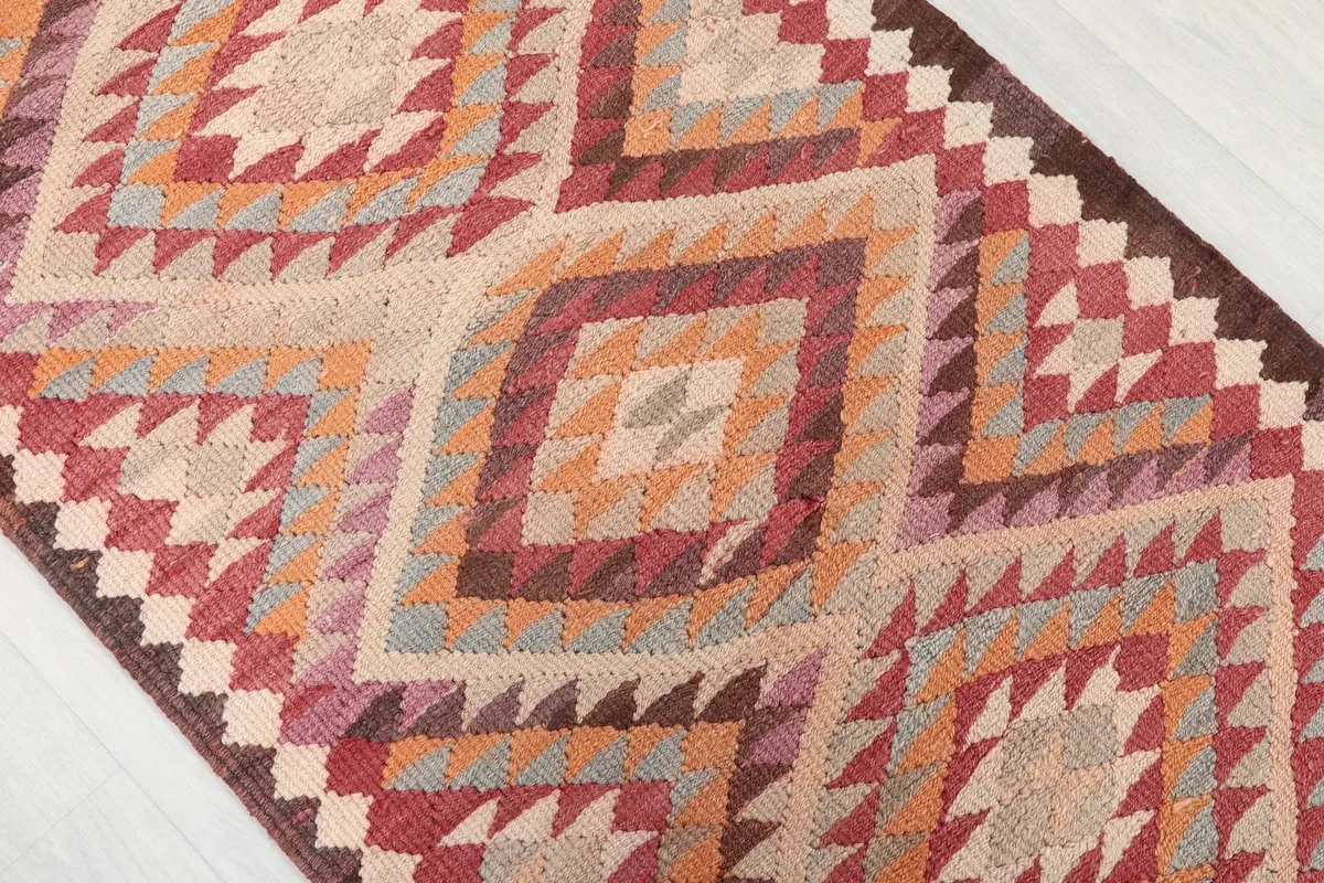 Close-up of the rug's surface, showing the hand-knotted texture and the subtle color shifts in the pattern