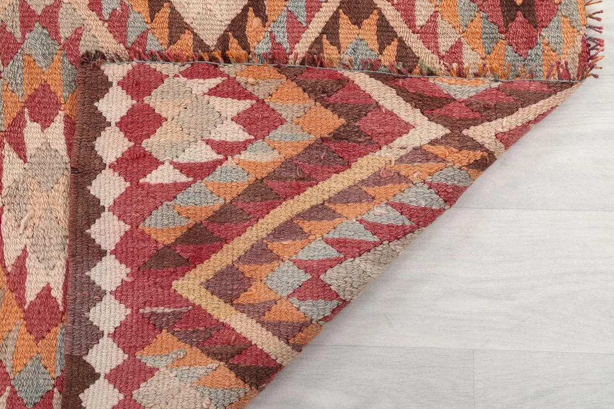 The reverse side of a corner of the rug, showing the cotton foundation and the knotting detail