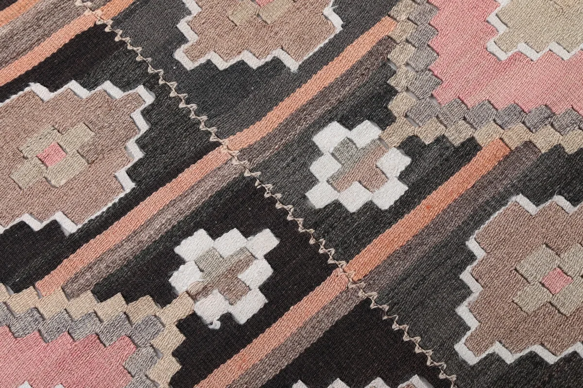 Close-up detail of the intricate geometric motifs and color variations in the rug