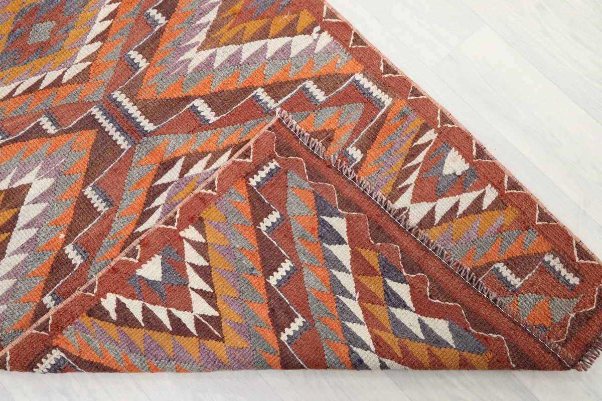 Folded corner of the rug revealing the wool pile texture and the hand-knotted construction.