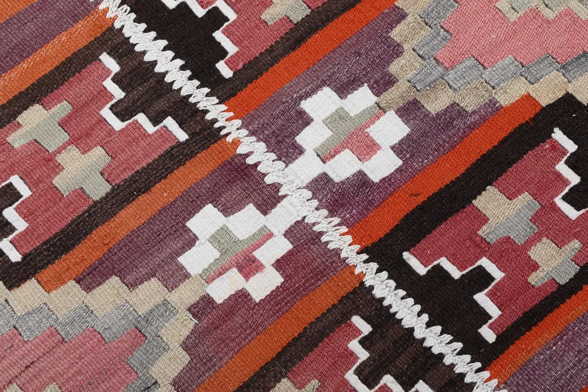 Detailed view of the hand-knotted texture and varied color blocks in the geometric design