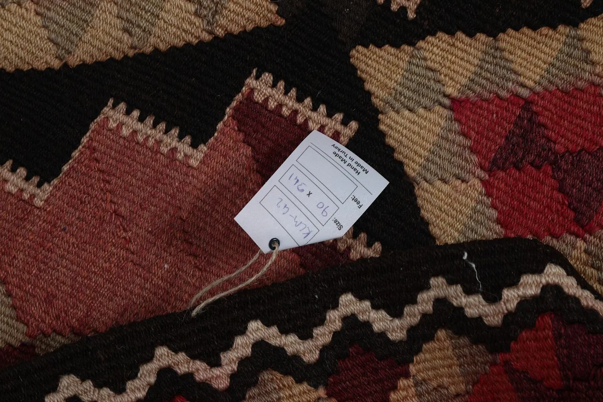 Close-up of the back of the rug with a product tag, revealing the tight knotting