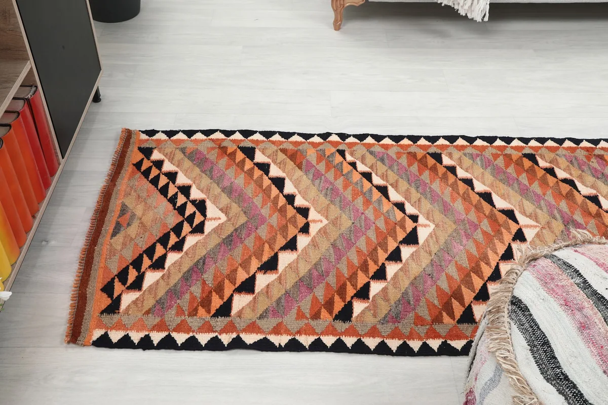Angled view of the runner rug in a room, emphasizing its length and the chevron pattern