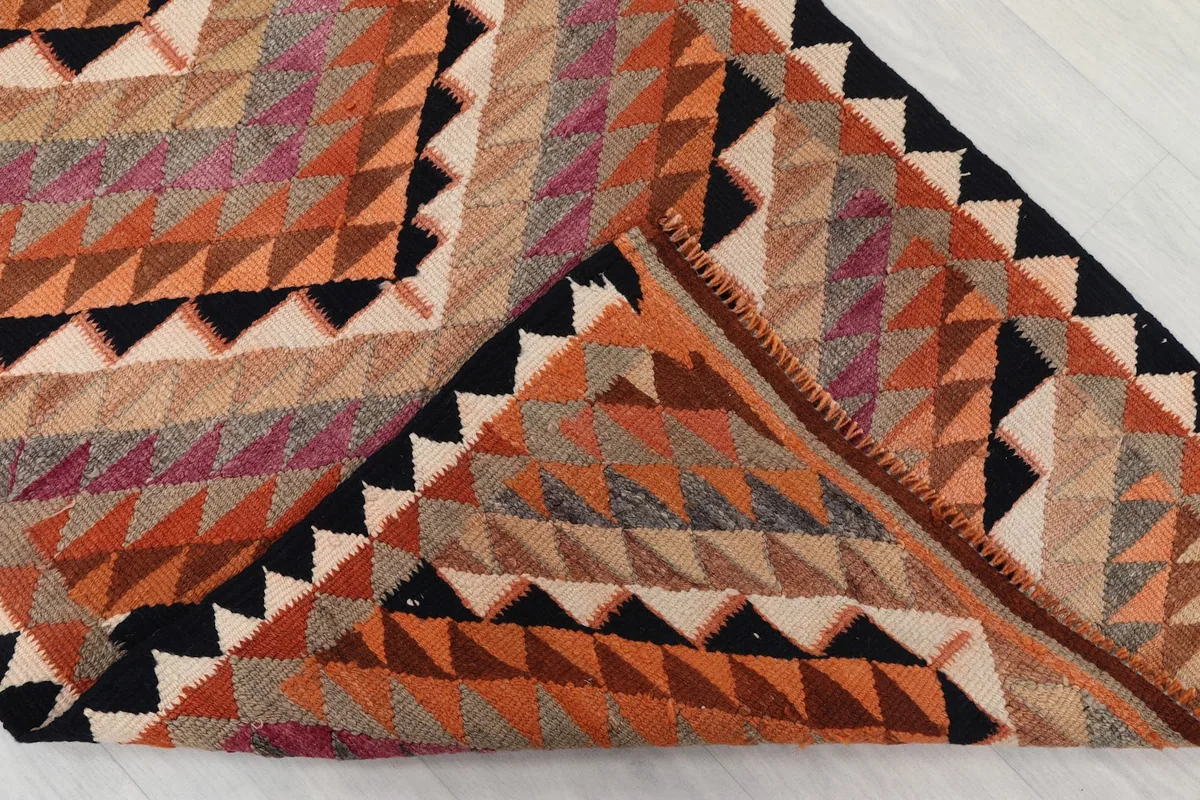 Folded corner of the rug revealing the wool pile and cotton foundation