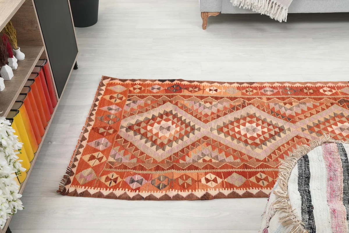 Long shot from above, showing the runner rug extending across the room floor