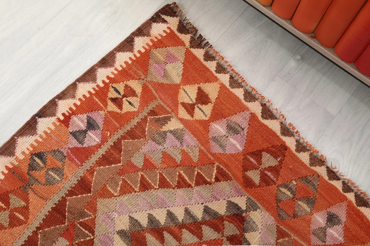 Corner detail of the rug, highlighting the varied colors and craftsmanship of the border