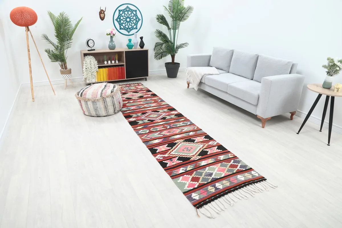 Long view of the rust and multicolor geometric runner rug extending through a contemporary space.