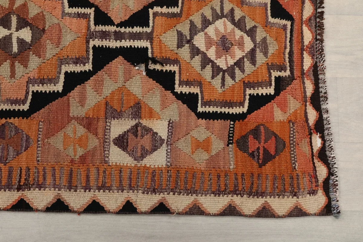 Detailed view of the intricate geometric motifs and border design of the rug