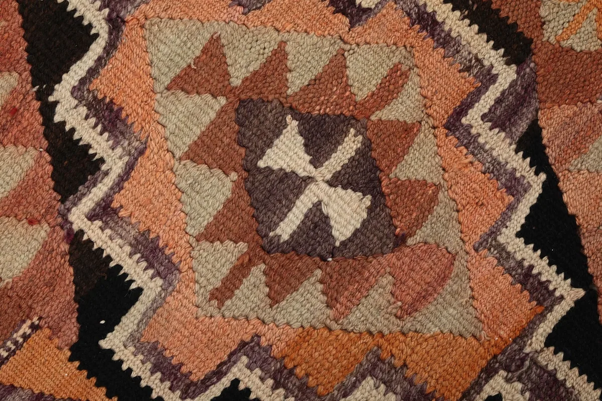 Extreme close-up of a central geometric motif with beige and purple accents