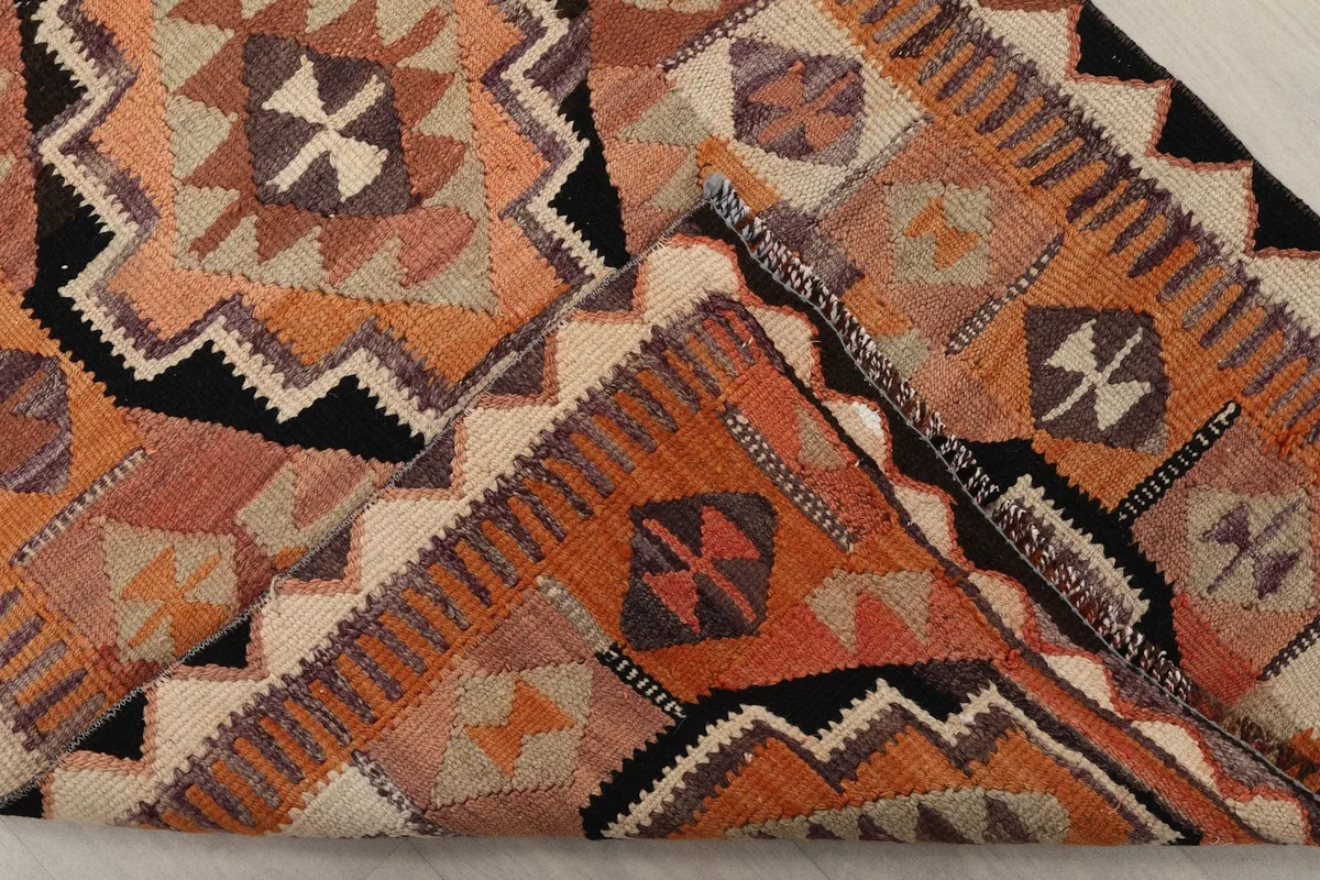 Folded corner of the rug revealing the density of the hand-knotted wool pile and cotton foundation
