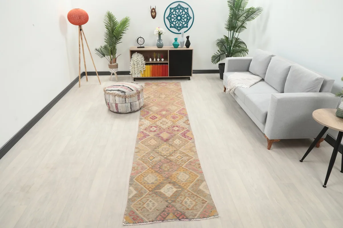 Vintage runner rug in a living room setting with a light gray couch and decorative pouf