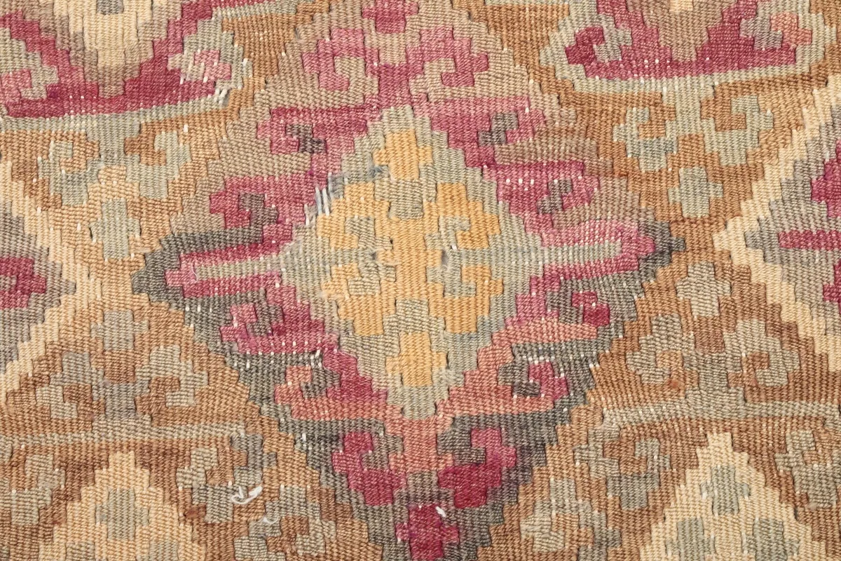 Close-up of the low wool pile and faded rose and gold geometric design