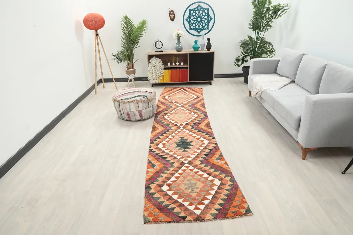 Vintage Anatolian runner rug displayed in a modern living room setting, showing its length and colors.