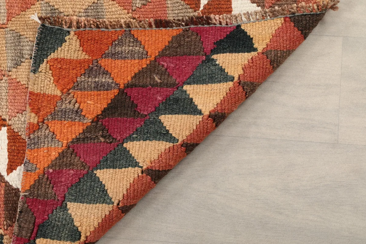 Close-up of the back of the rug, revealing the tightly woven cotton foundation and wool knots.