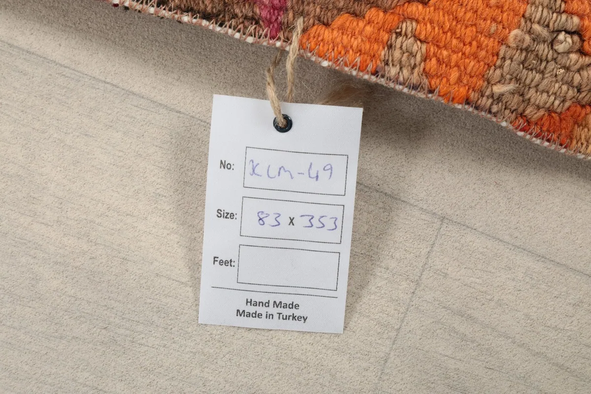 Product tag attached to the rug, showing 'KLM-69' and '83 x 353 cm' details.