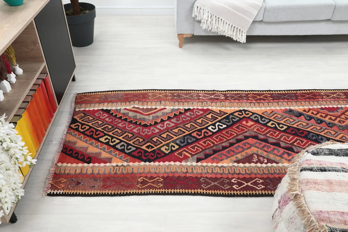 View of the runner rug from a higher angle, showcasing its placement in a living area with a sofa.