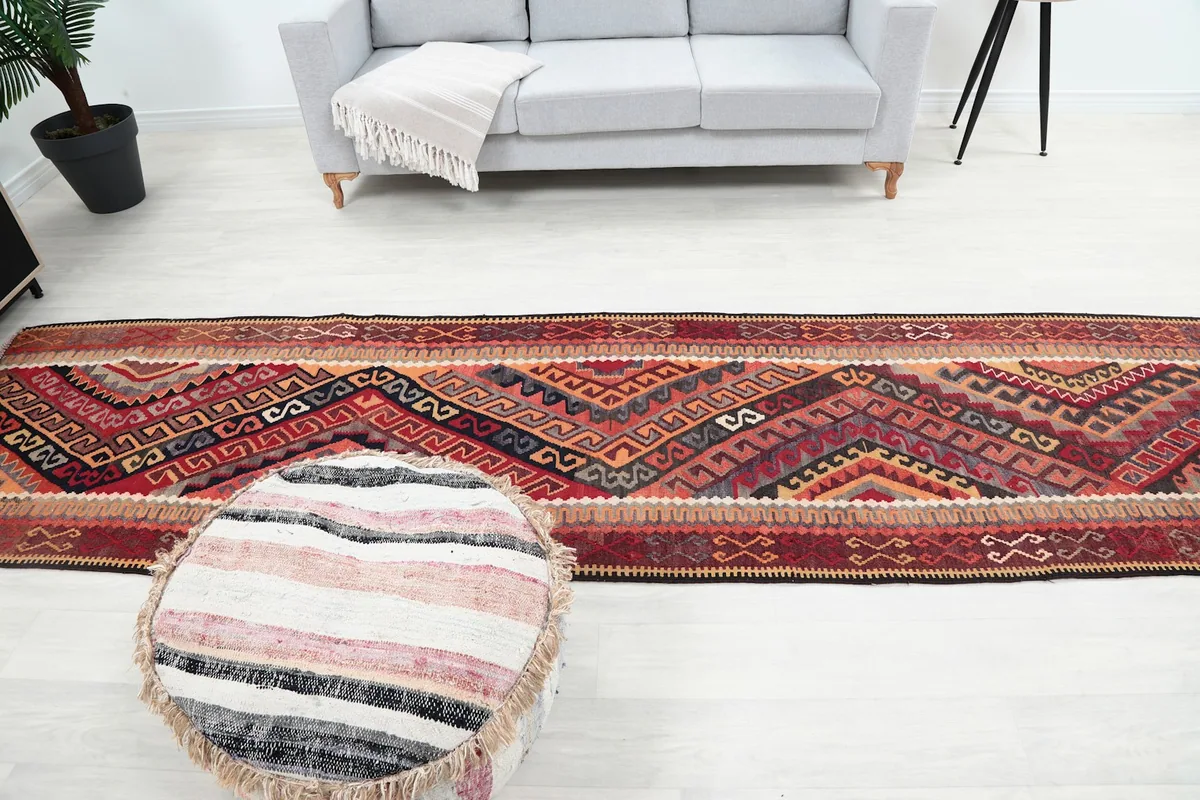 Full length room view of the red geometric runner rug, illustrating its impact on the decor.