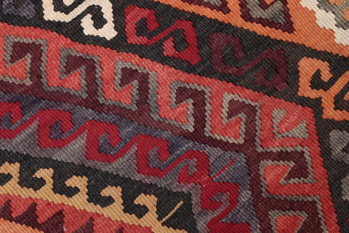 Extreme close-up of the low wool pile, highlighting the texture and color variations of the geometric design.