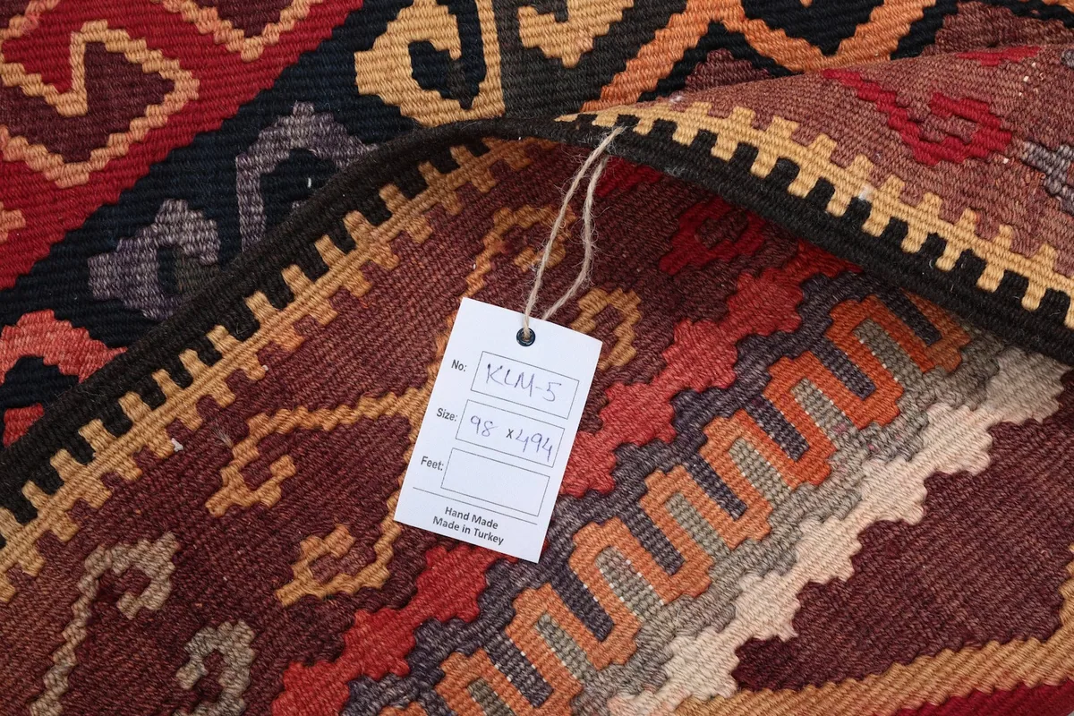 Close-up of the product tag attached to the rug, showing its dimensions and origin.