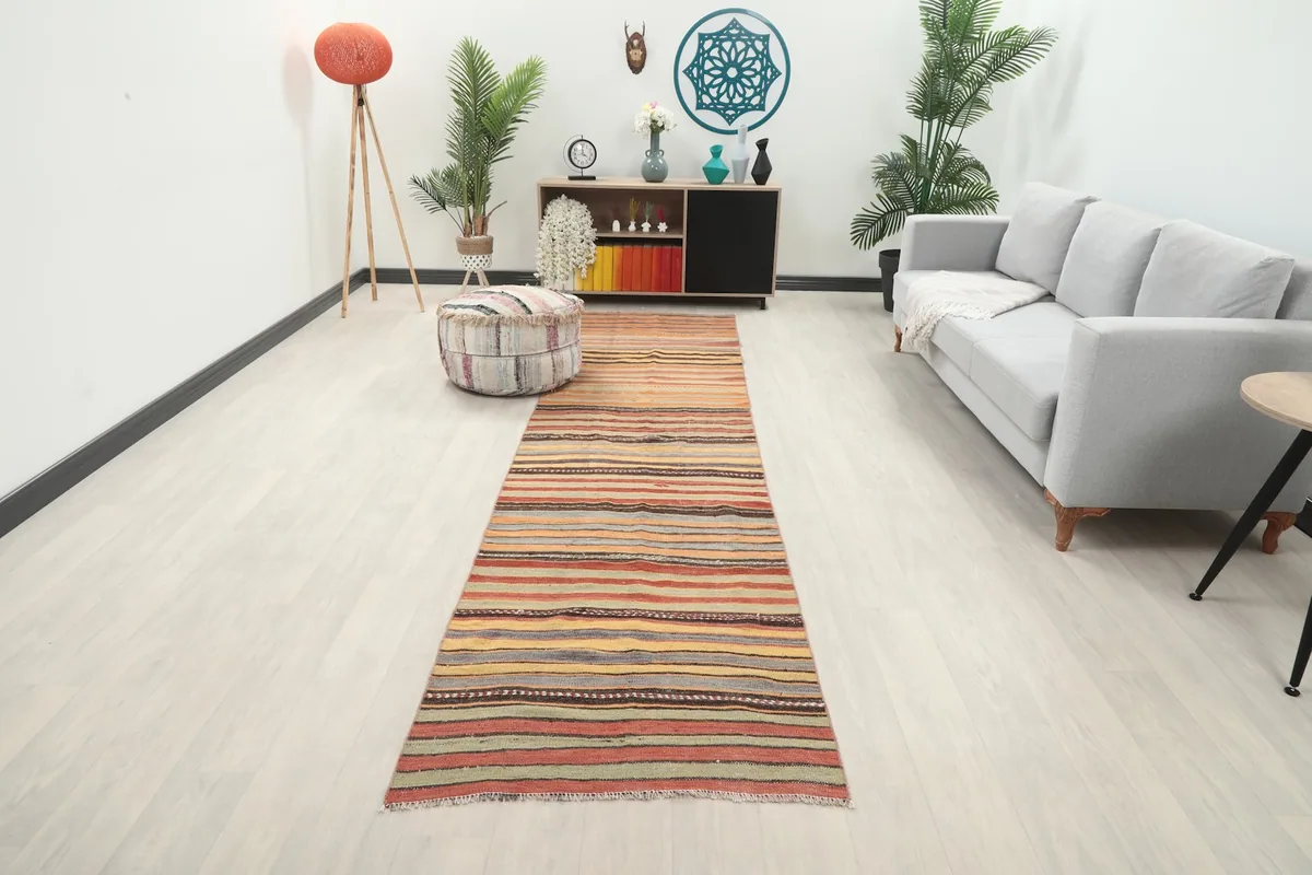 Vintage runner rug displayed in a modern living room setting with a gray sofa and wooden furniture