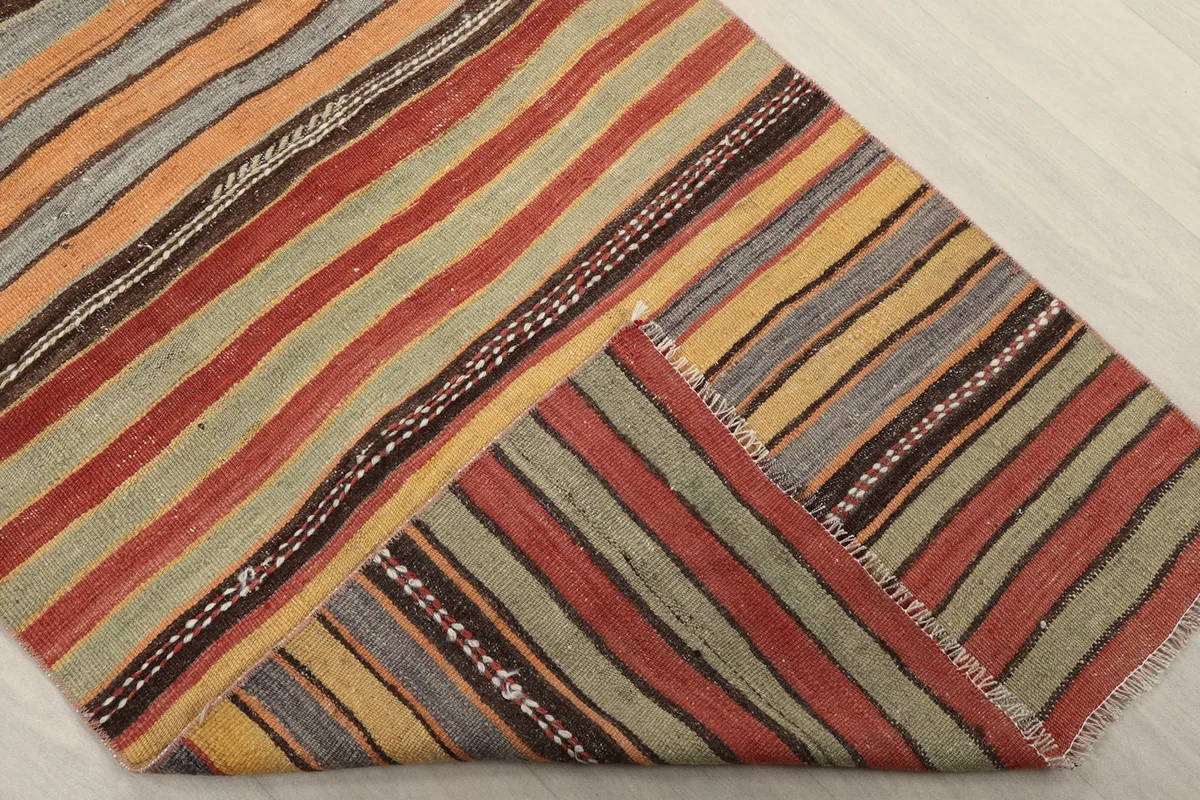 Folded corner of the runner rug, showing the reverse side and the hand-knotted construction