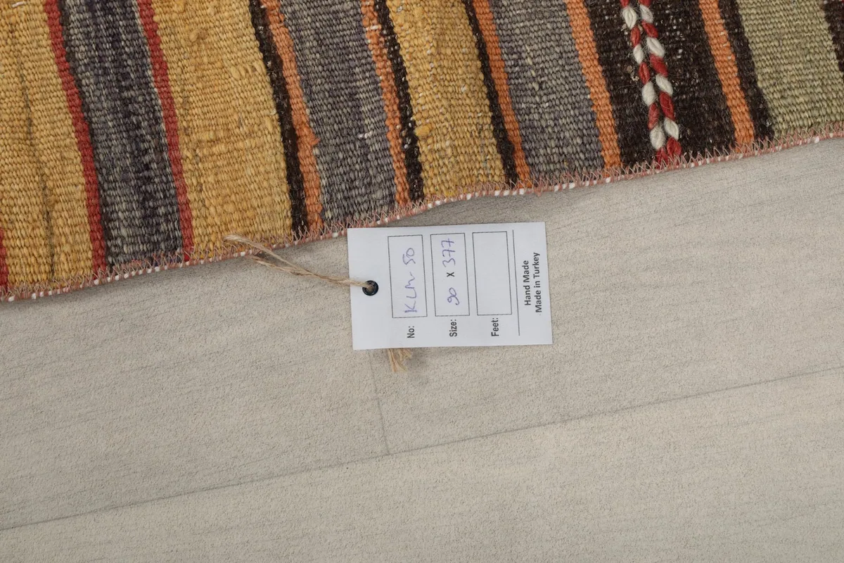 Product tag attached to the vintage runner rug, showing size and origin details