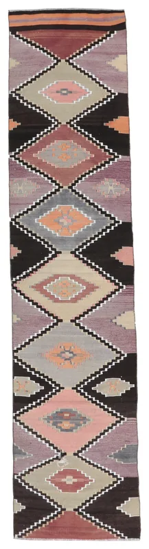 Full overhead view of the black, rose, gray, and purple geometric Anatolian runner rug
