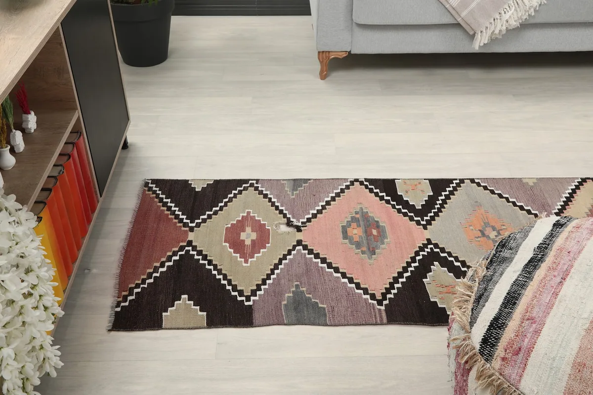 Overhead view of a section of the runner rug in a room, highlighting its length and pattern