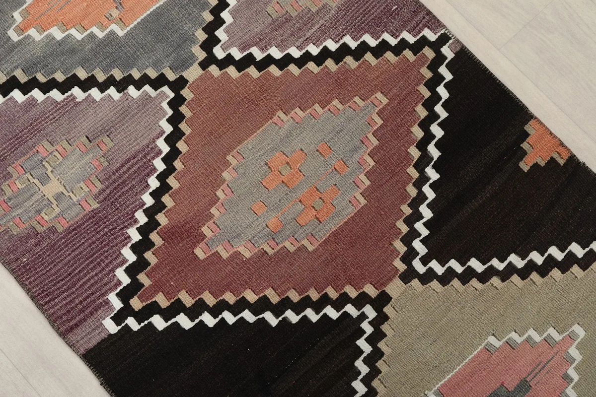 Detailed view of the interlocking geometric diamond patterns and colors on the runner