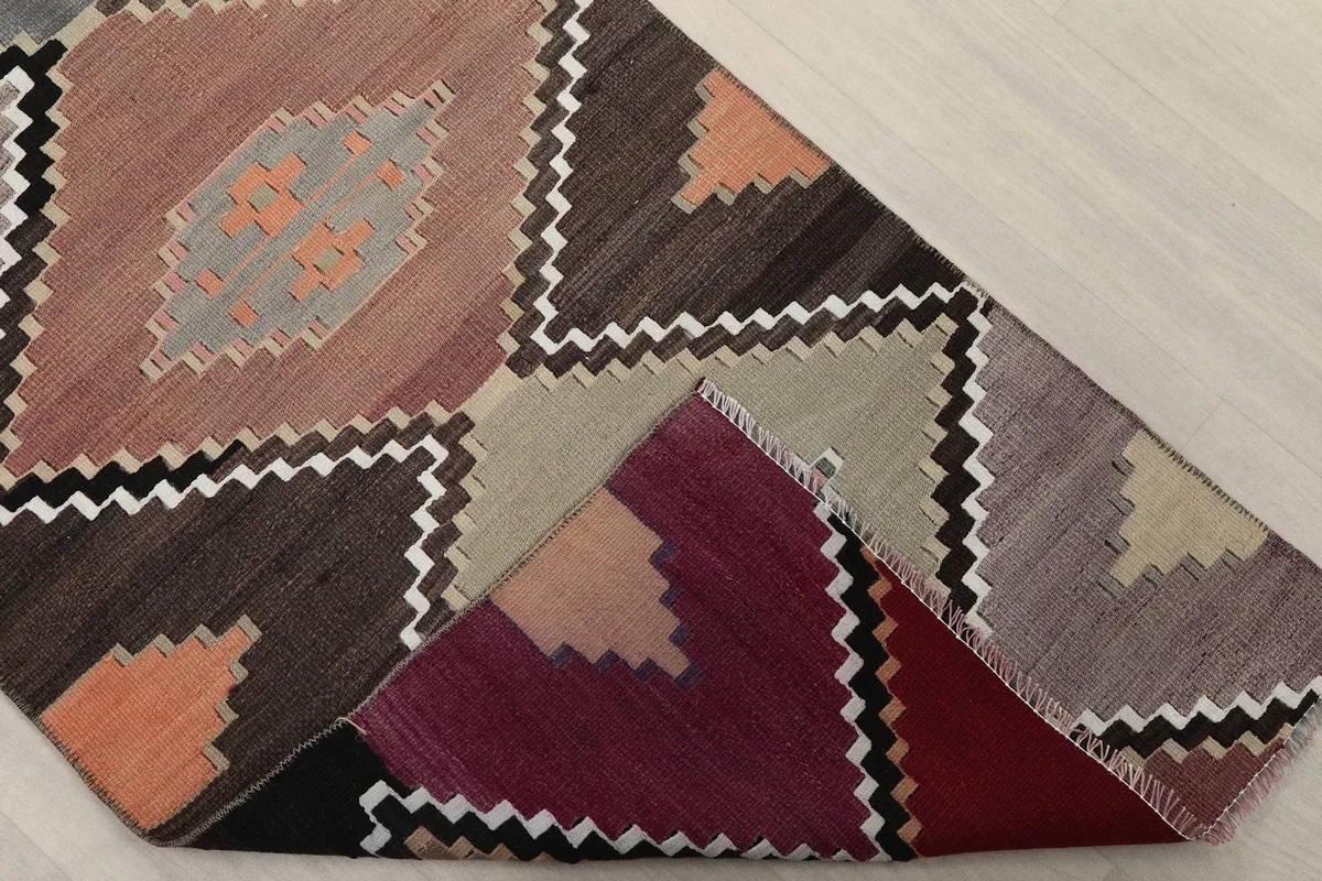 Corner of the rug folded to show the hand-knotted cotton foundation and wool pile