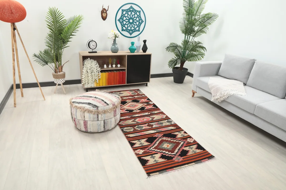 Runner rug placed in a room with a light gray sofa and wooden console table, showing its scale