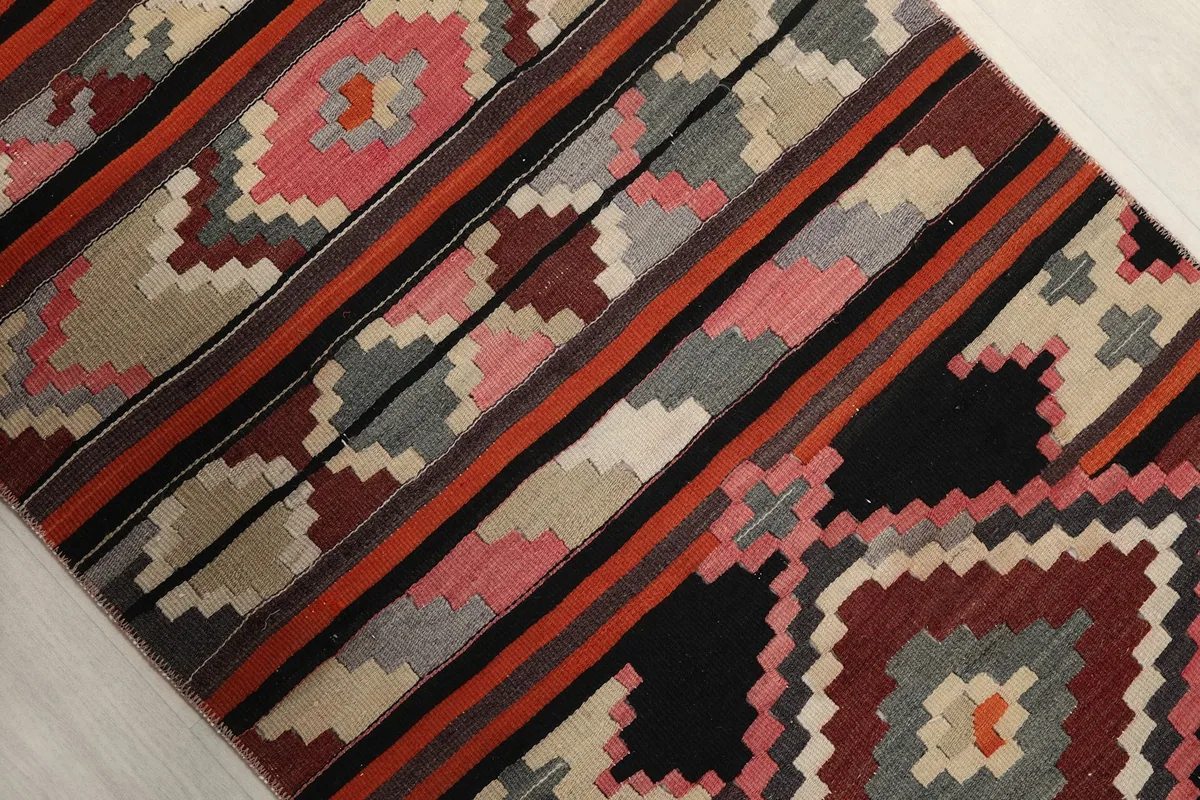 Diagonal close-up of the rug's intricate tribal and geometric design elements and color bands
