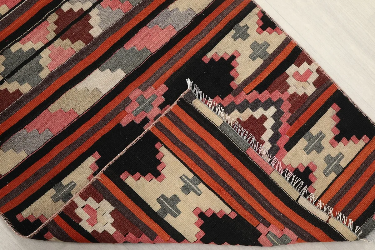 Folded corner of the rug, showing the reverse side and the hand-knotted construction