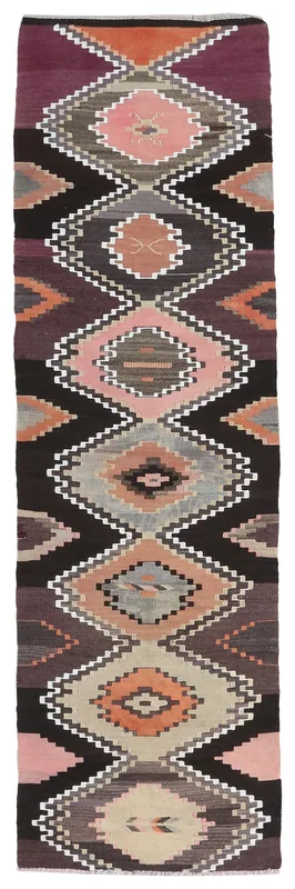 Full overhead view of the black, pink, and rust geometric vintage Anatolian runner rug