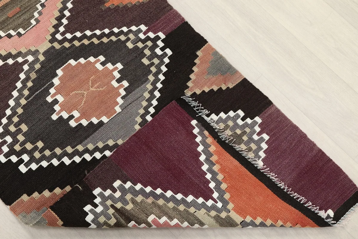 Corner of the runner rug folded to show the hand-knotted wool pile and cotton foundation