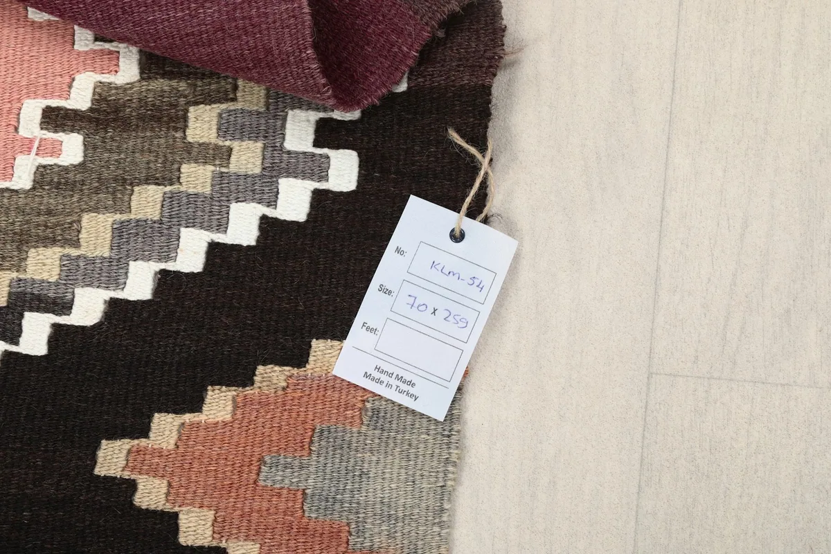 View of the rug's corner with a product tag displaying size and origin information