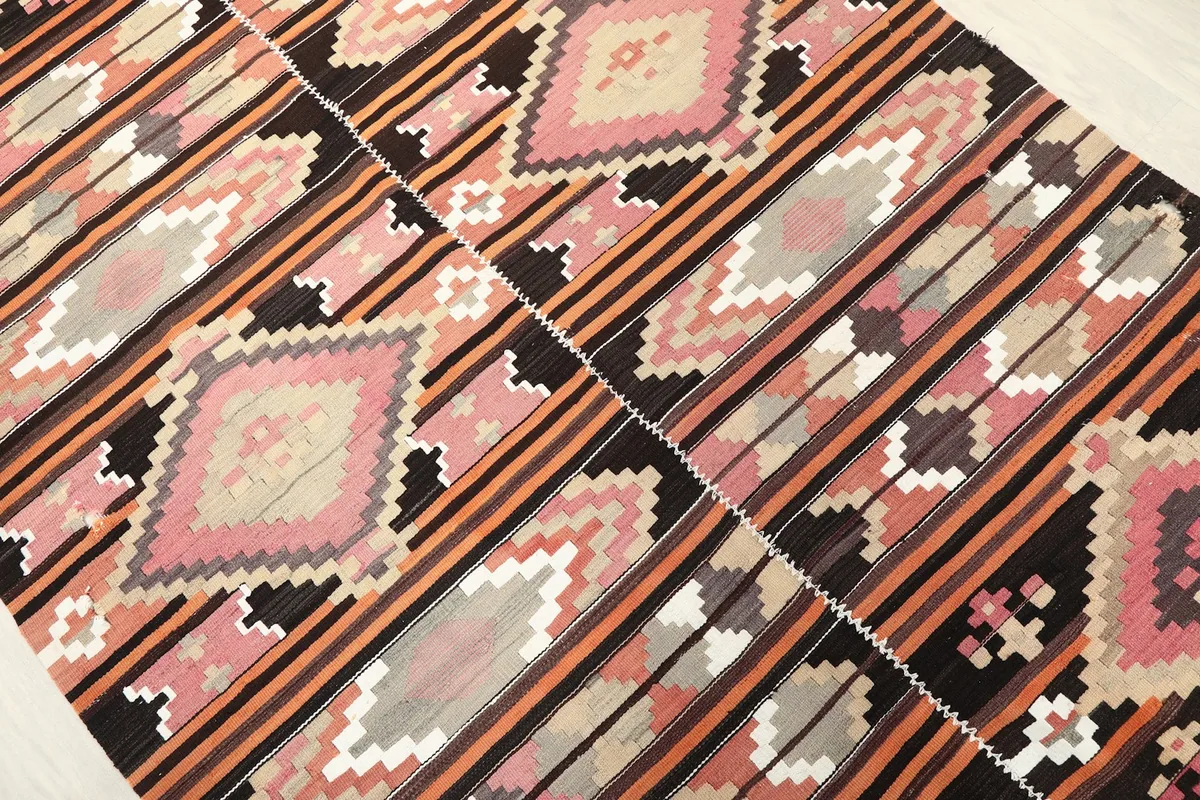 Angled shot highlighting the striped and diamond patterns of the rug