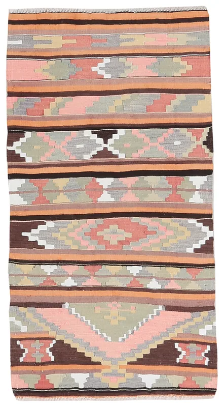 Full overhead view of a vintage pink and orange geometric Anatolian rug on a white background