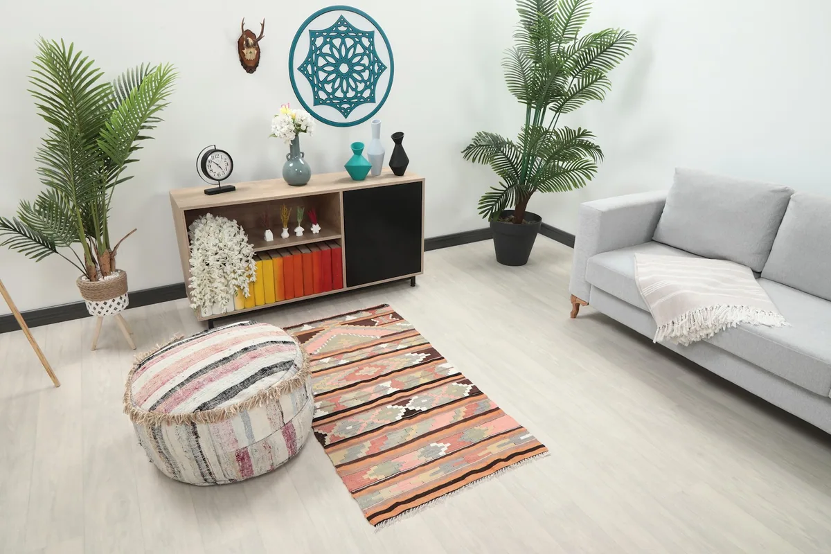 Angled view of the vintage Anatolian rug in a room, showing its scale next to furniture