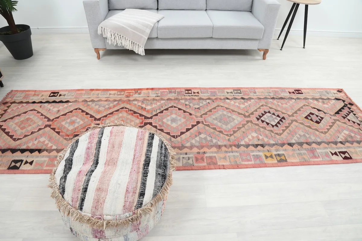 Wide shot of the runner in a room, showing its scale relative to a sofa and ottoman