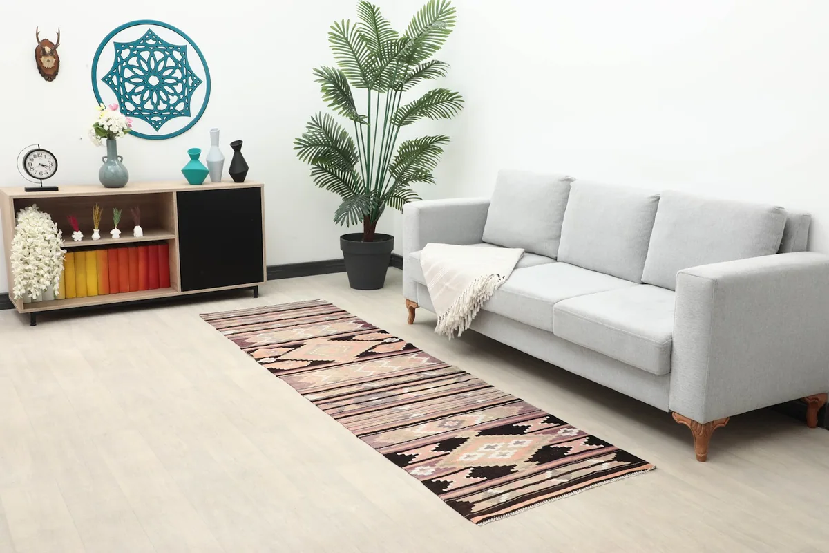Long shot of the runner in a living room with a sofa, plant, and cabinet, highlighting its scale