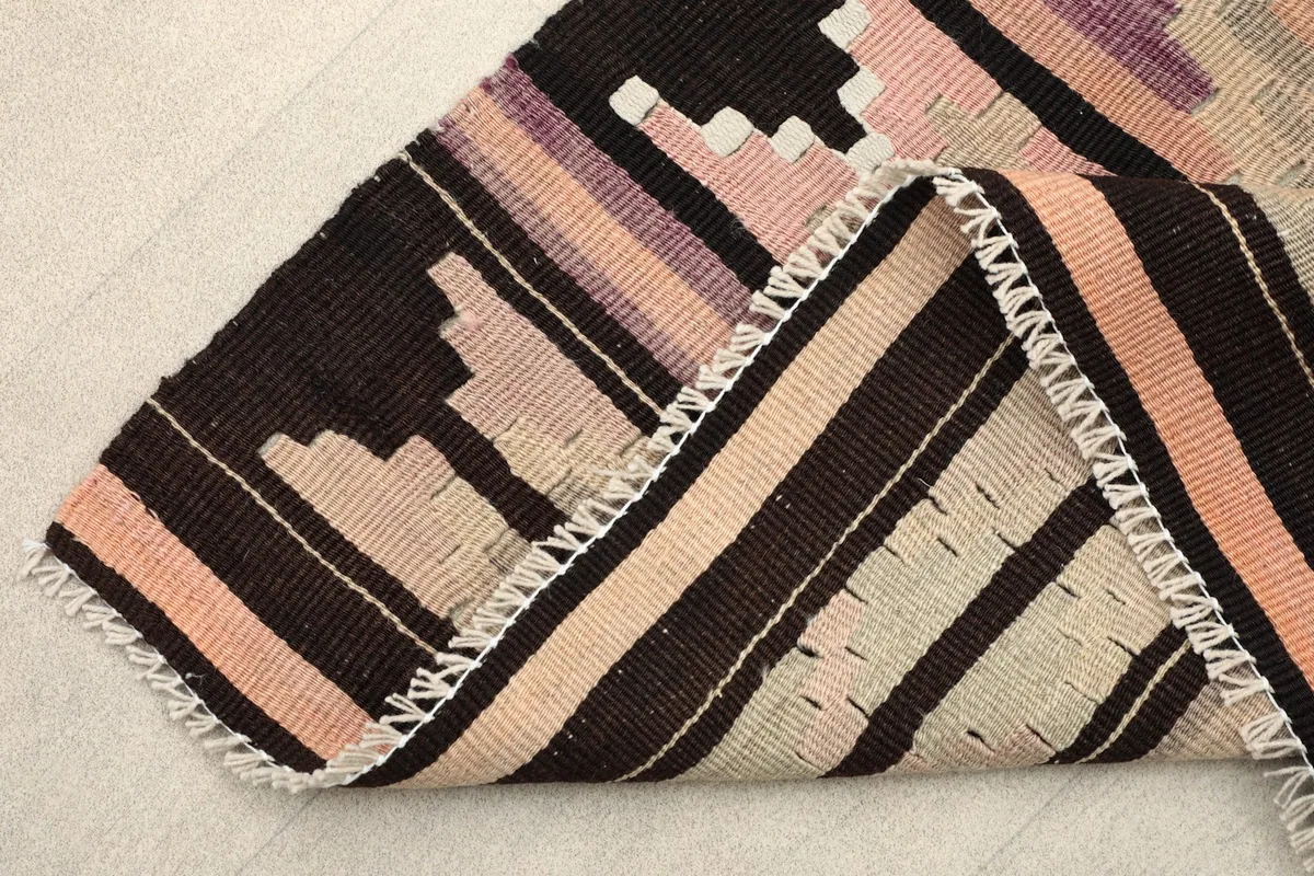 Close view of the rug's edge and low wool pile, showing its construction