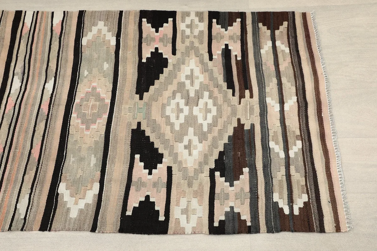 Close-up detail of the central beige and black geometric pattern with pink and gray accents