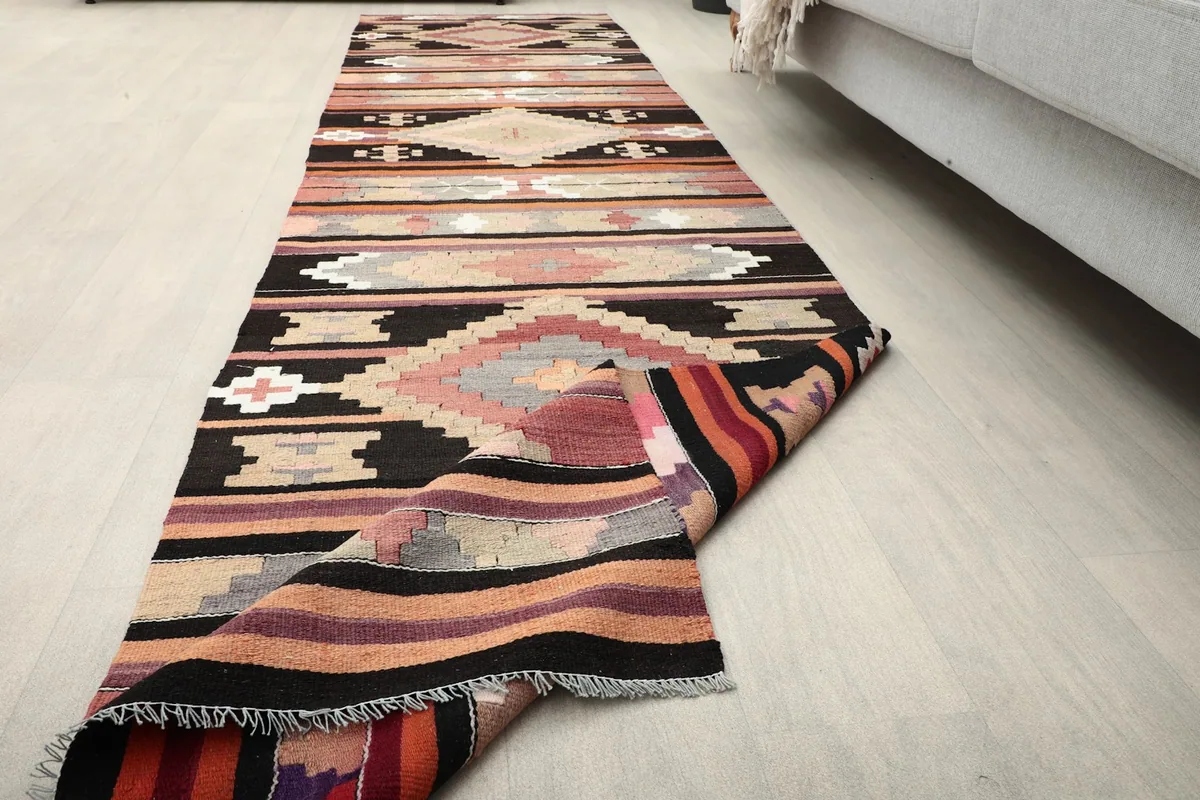 Angled view of the runner with one end folded back, revealing the reverse side's colors