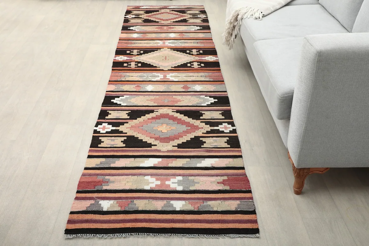 Vintage Anatolian runner rug extending into a modern living space with a light gray sofa