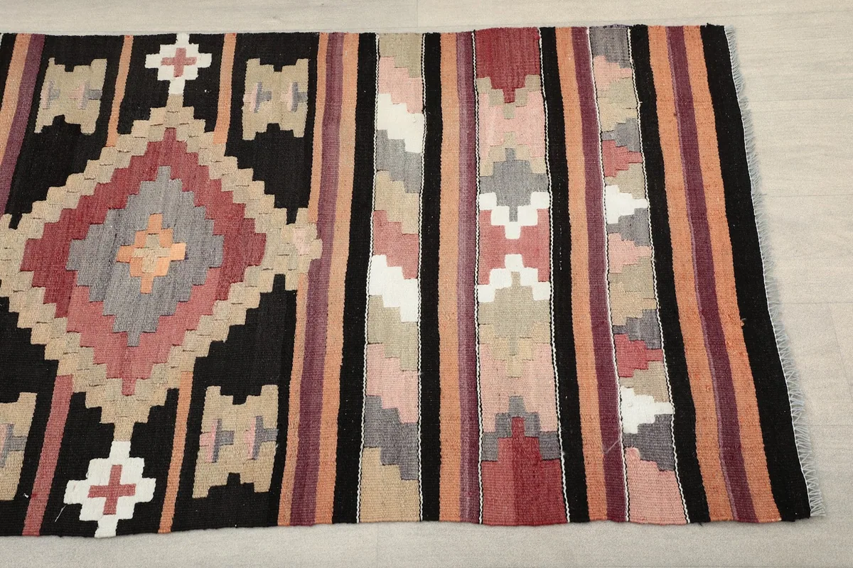 Close-up of the runner's patterns, showing black, rose, orange, and gray geometric motifs