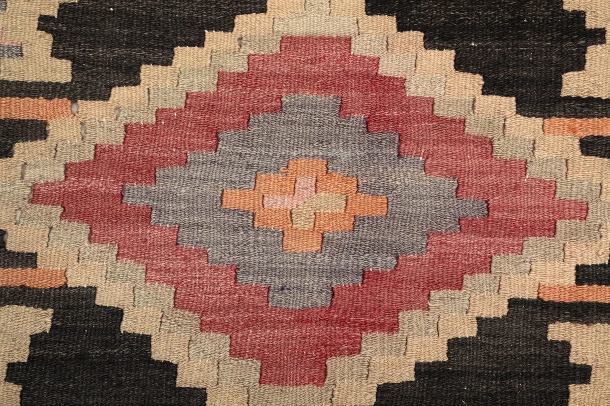 Close-up of the wool pile and intricate hand-knotted details of the central motif