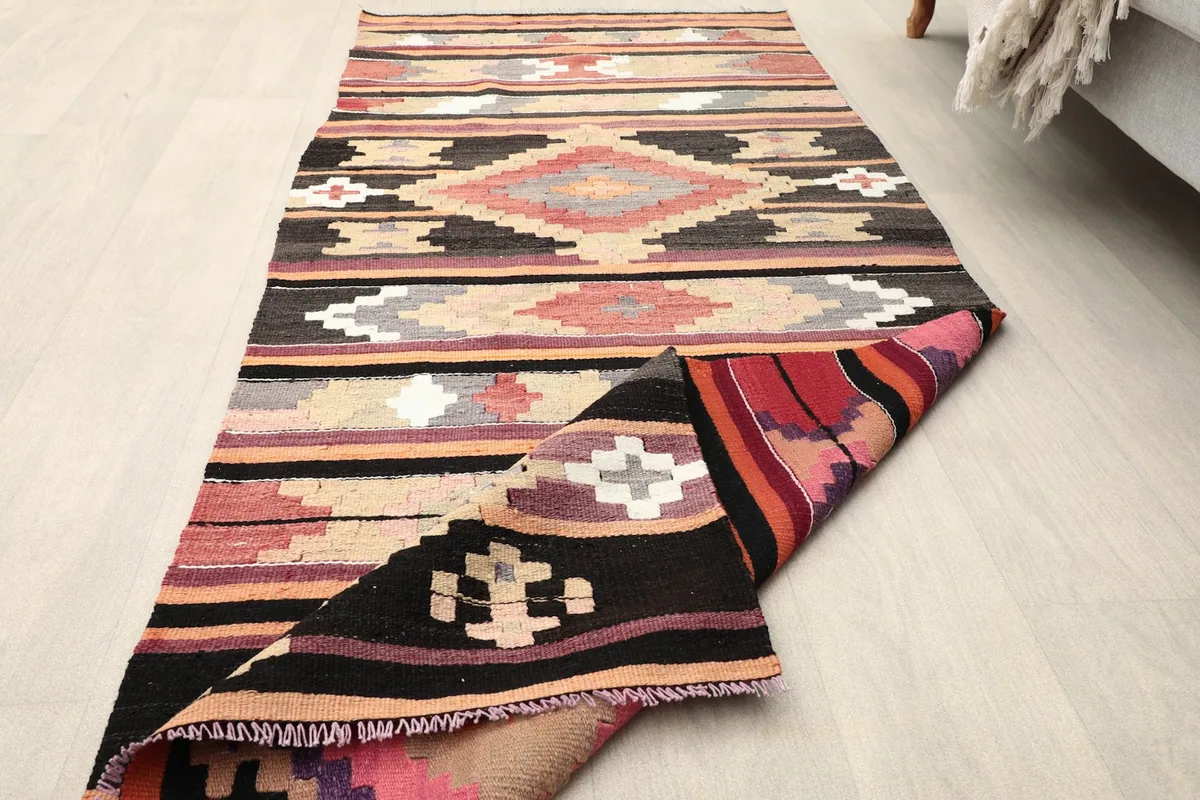 Rug partially folded back to show the reverse side and the colors on the back