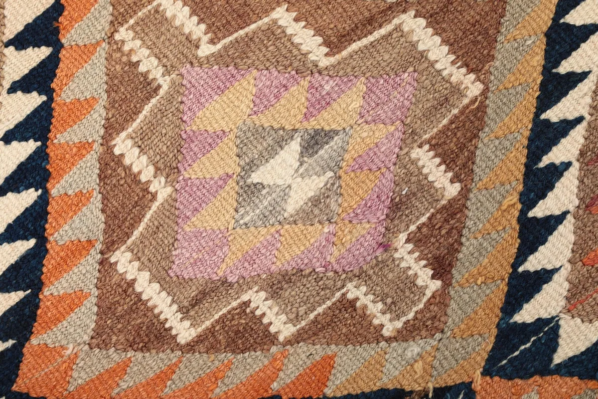 Extreme close-up of a central geometric motif, highlighting individual knots and colors