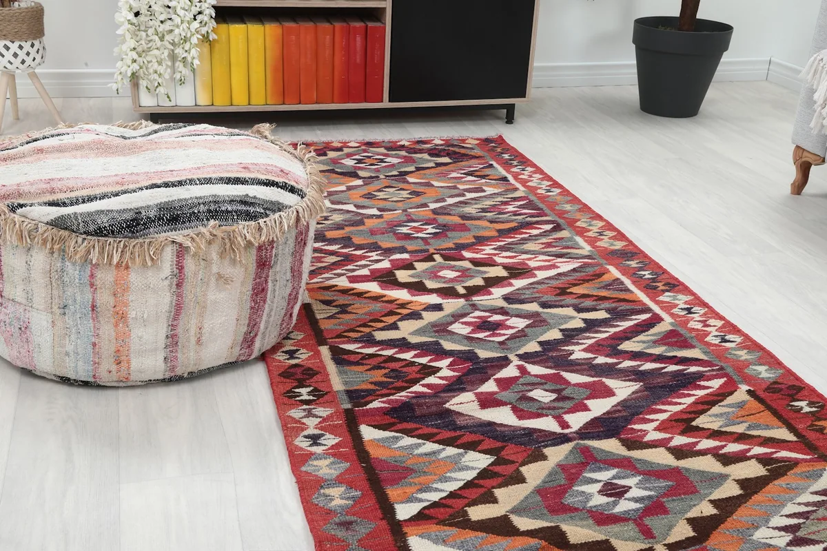 Close-up of the runner's vibrant geometric patterns and colors next to a woven ottoman